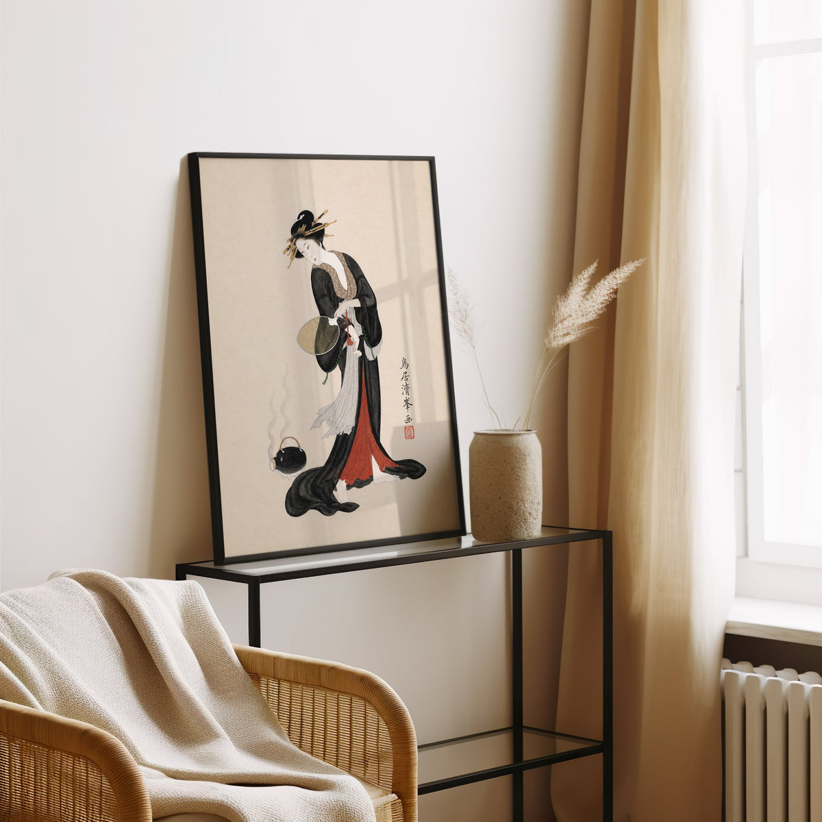 woman in black kimono with fan print in a black frame leaning on a glass console beside pampas grass