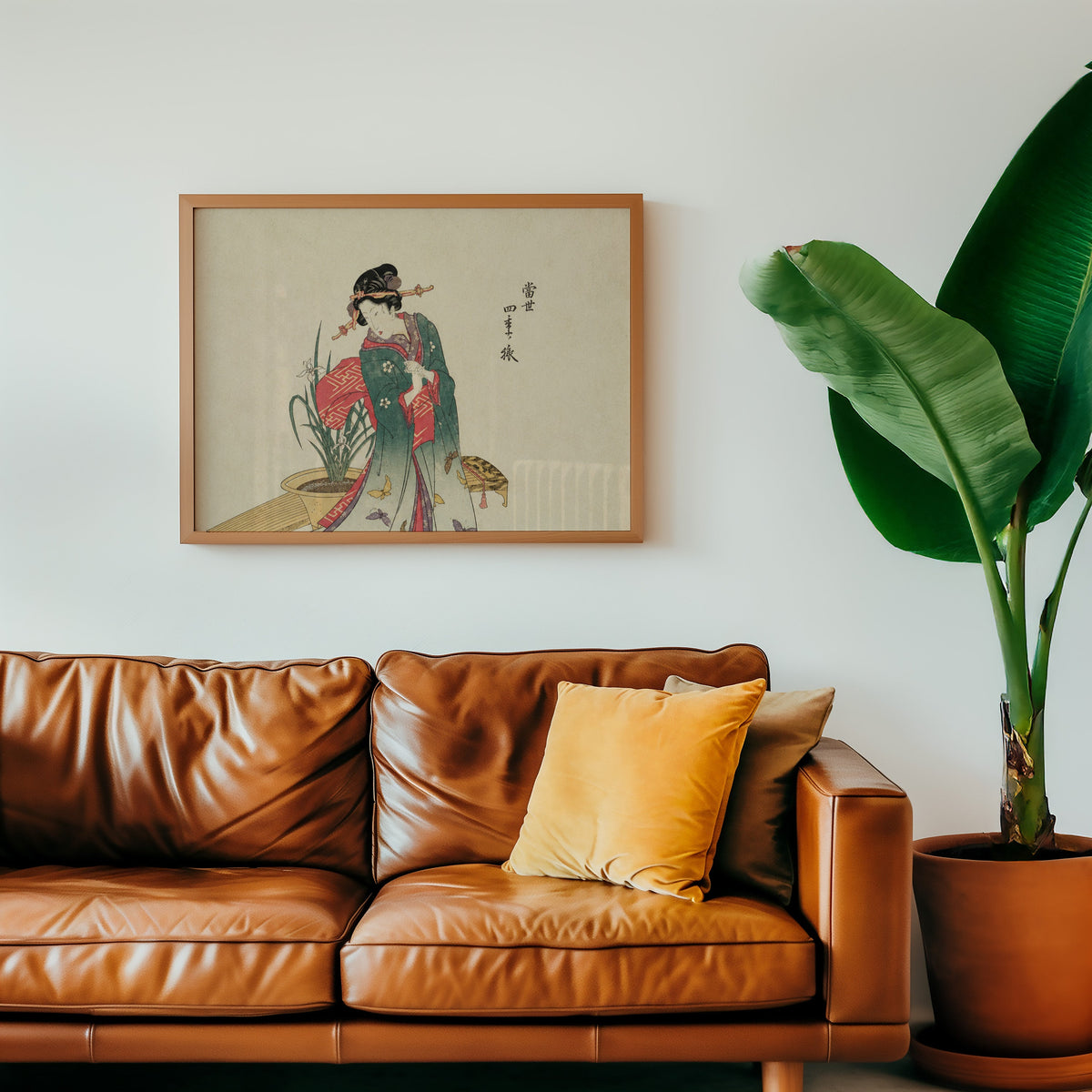 Woman in green kimono with butterflies print in a warm oak frame above a cognac leather sofa with a mustard pillow