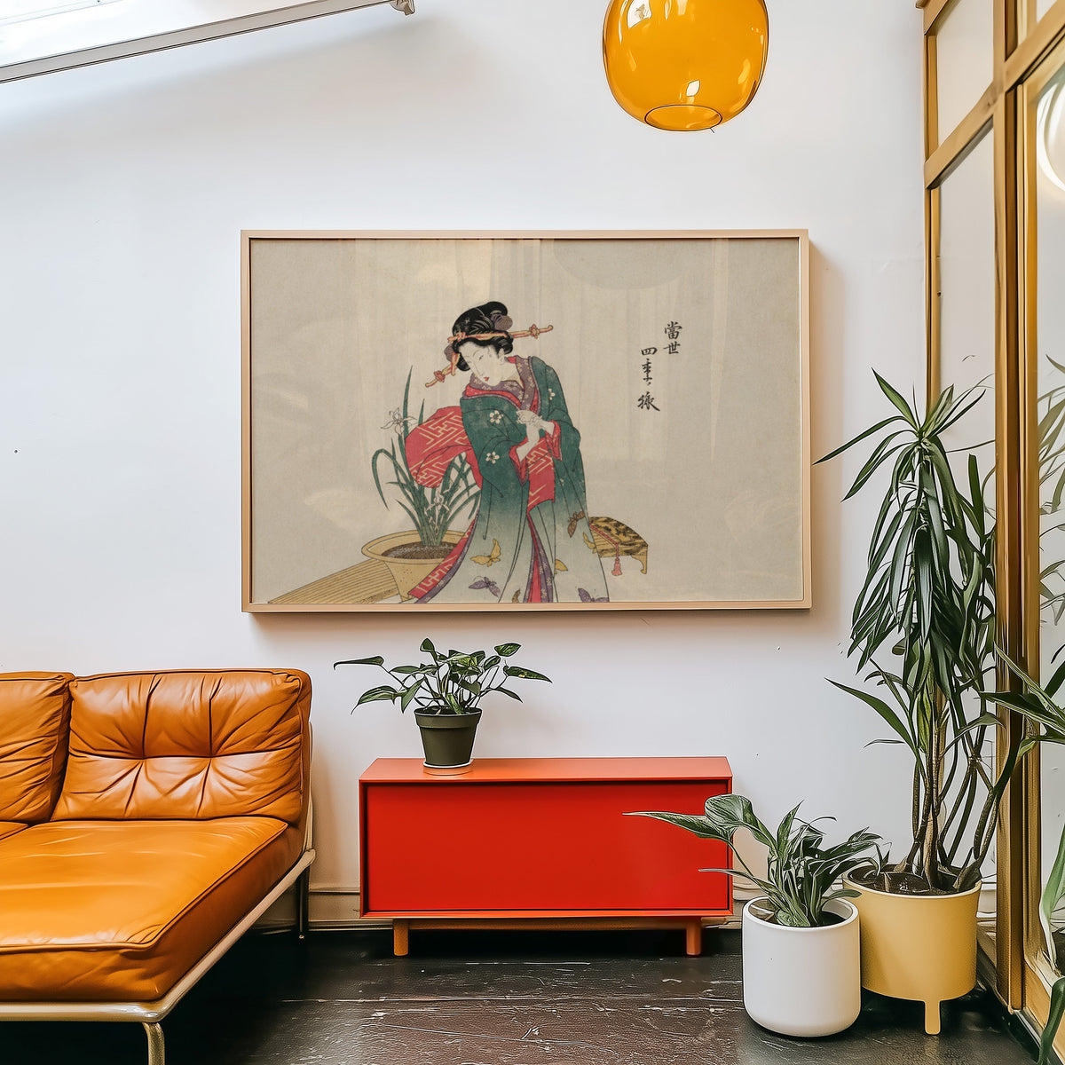 Woman in green kimono with butterflies print in a light wood frame above a red cabinet beside a tan leather daybed