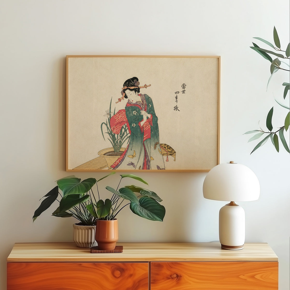 Woman in green kimono with butterflies print in a light oak frame above a wood sideboard with a white dome lamp