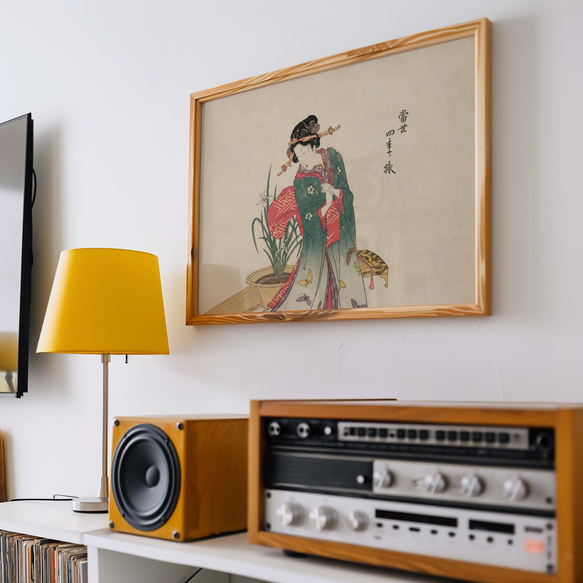 Woman in green kimono with butterflies print in a pine frame above a vintage stereo and a yellow table lamp