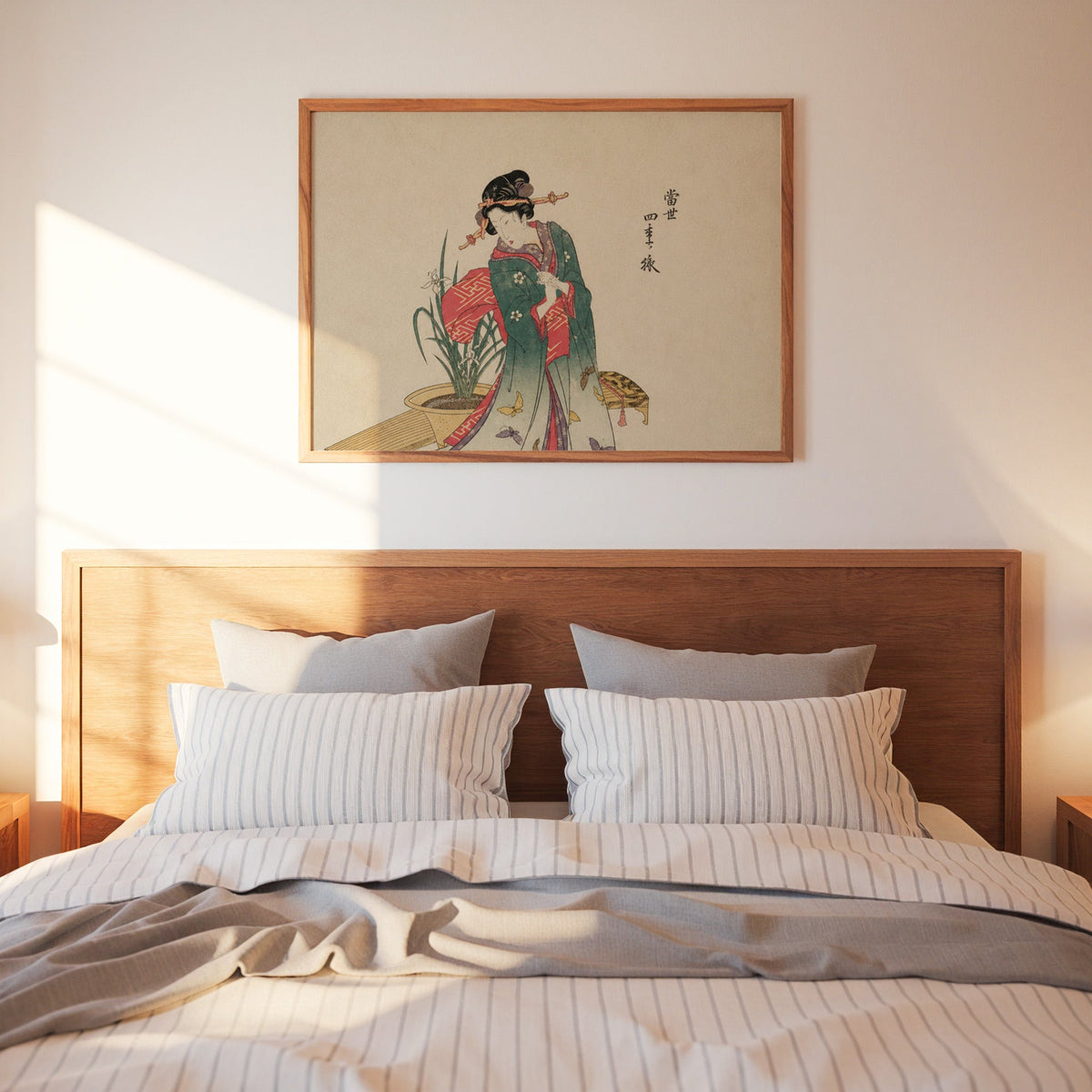 Woman in green kimono with butterflies print in a warm wood frame above a bed with striped linen bedding
