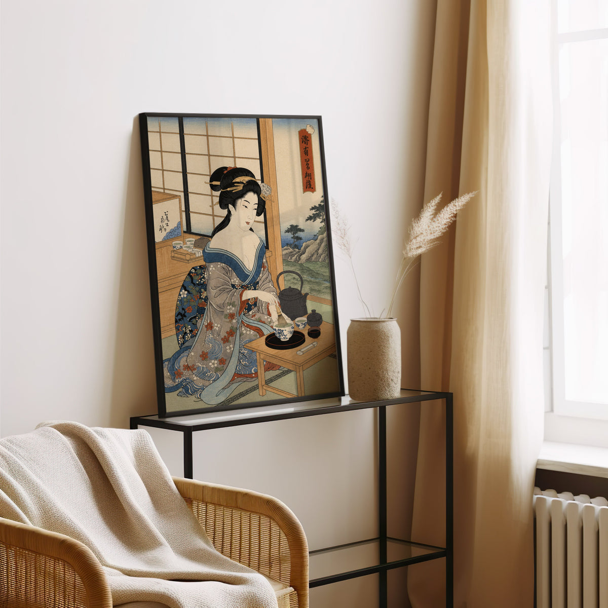 woman whisking matcha tea print in a black frame leaning on a glass console beside pampas grass