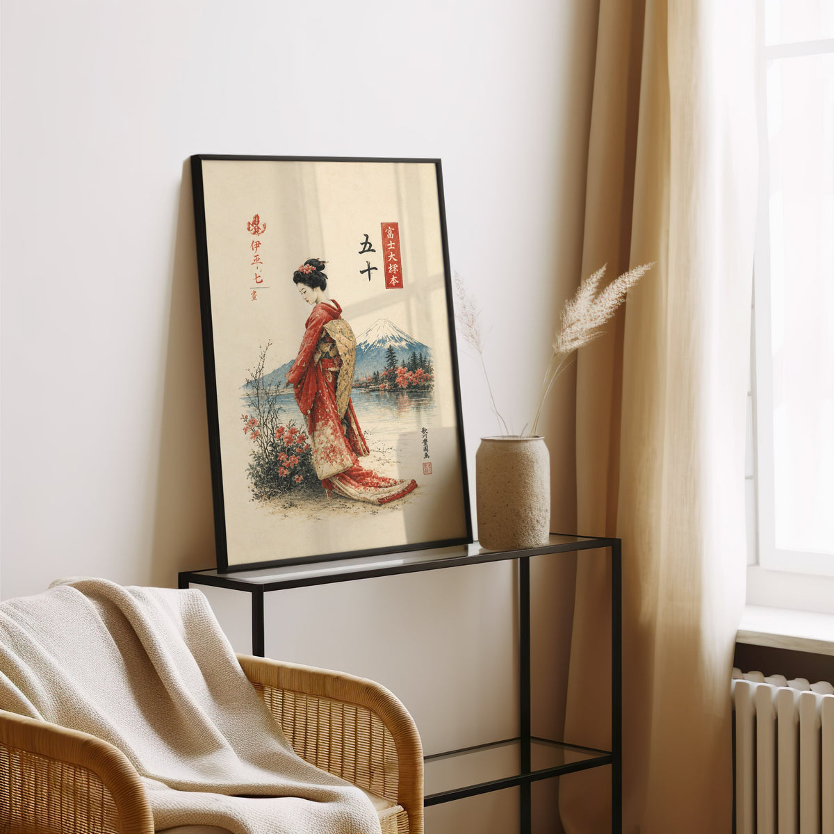 woman in red kimono by Mount Fuji print in a black frame leaning on a glass console beside pampas grass