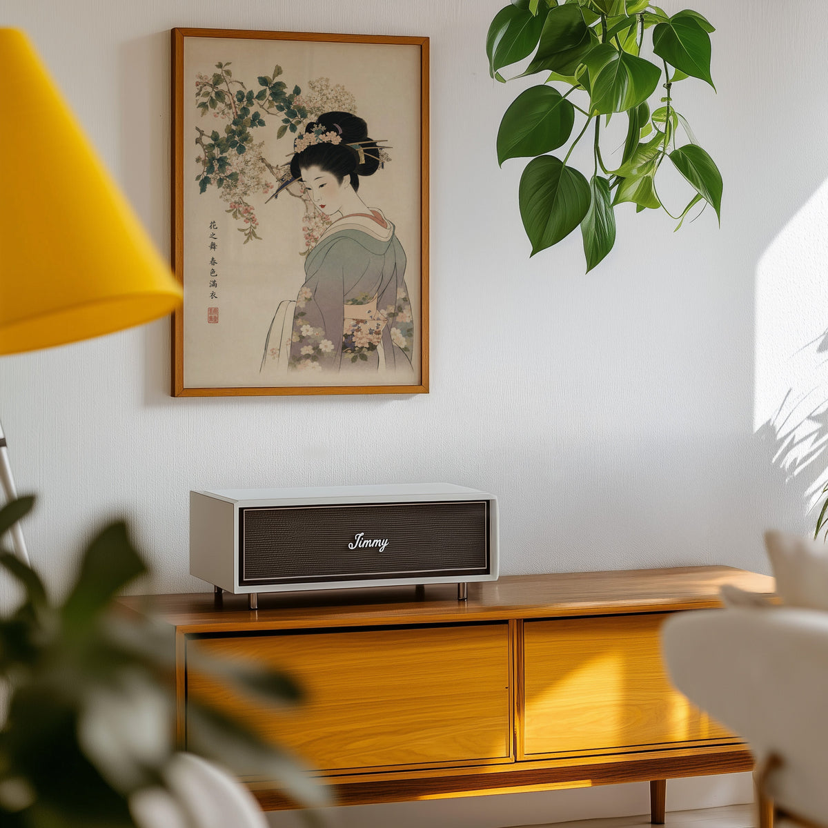 woman in lilac kimono under blossoms print in an oak frame above a teak mid-century sideboard with trailing pothos