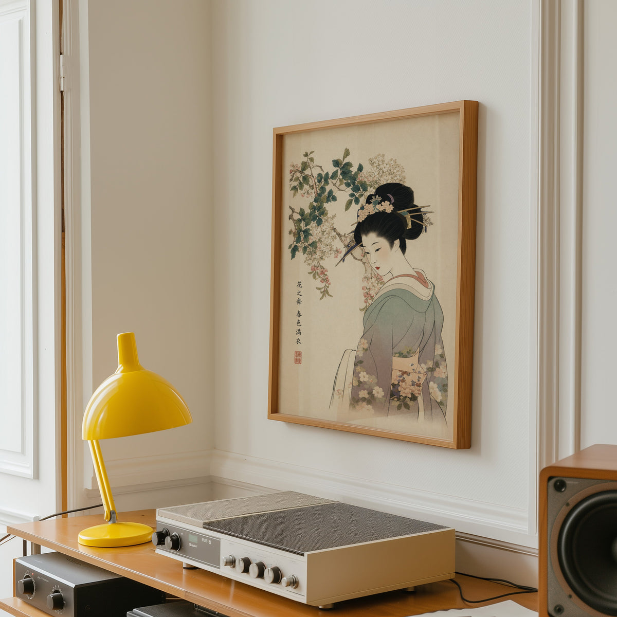 woman in lilac kimono under blossoms print in an oak frame above a vintage hi-fi shelf with a yellow desk lamp