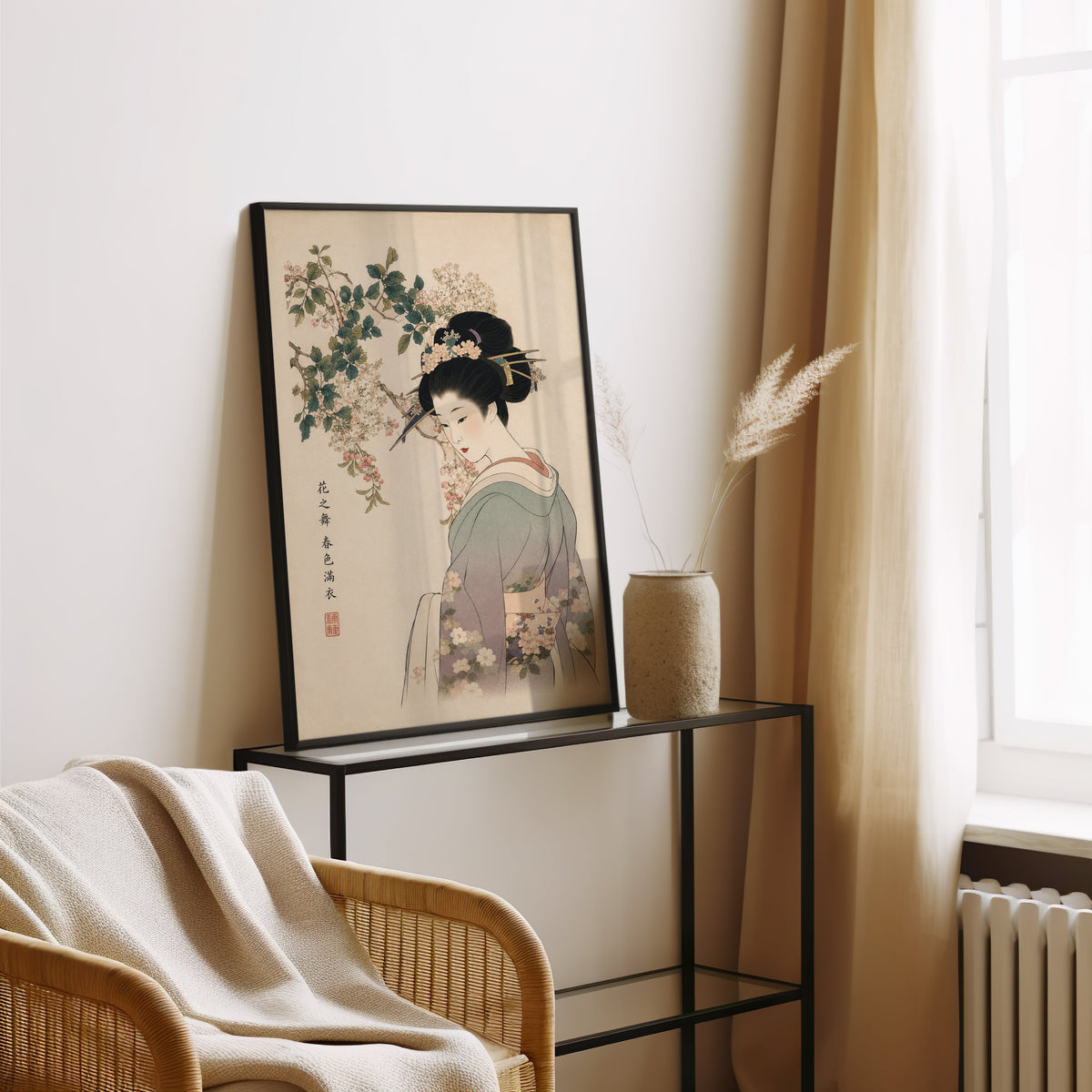 woman in lilac kimono under blossoms print in a black frame leaning on a glass console beside pampas grass