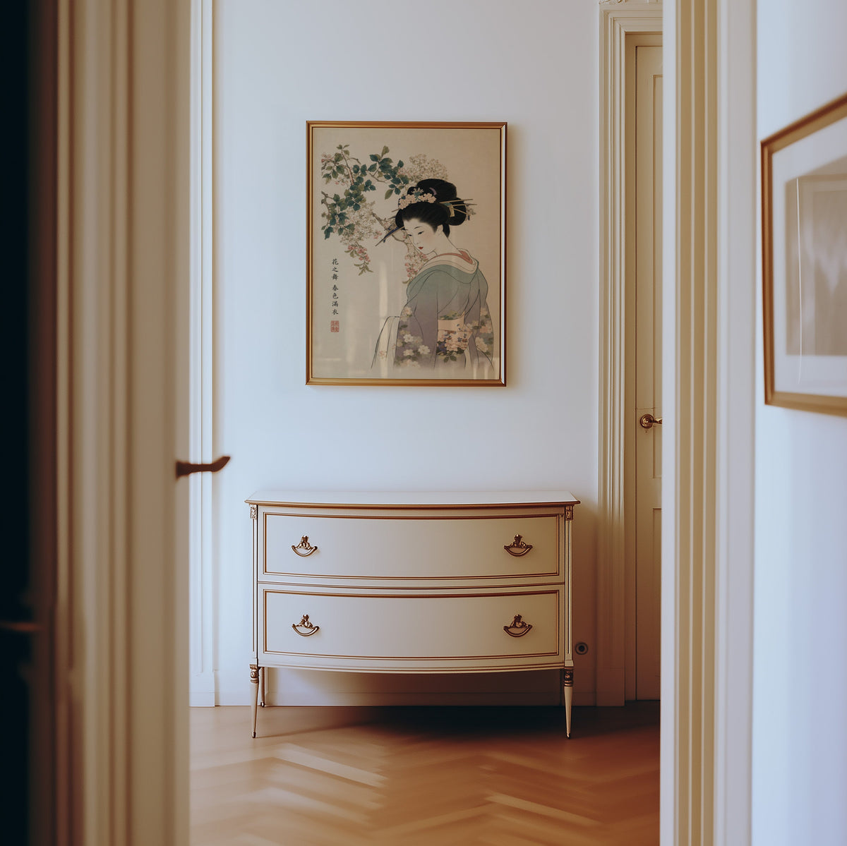 woman in lilac kimono under blossoms print shown in a gold frame in a hallway above a cream dresser