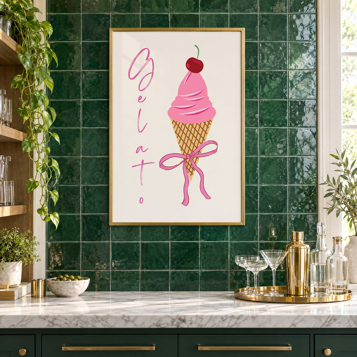 Gelato pink cone with bow print in a brass frame on emerald green tiles above a home bar with coupe glasses