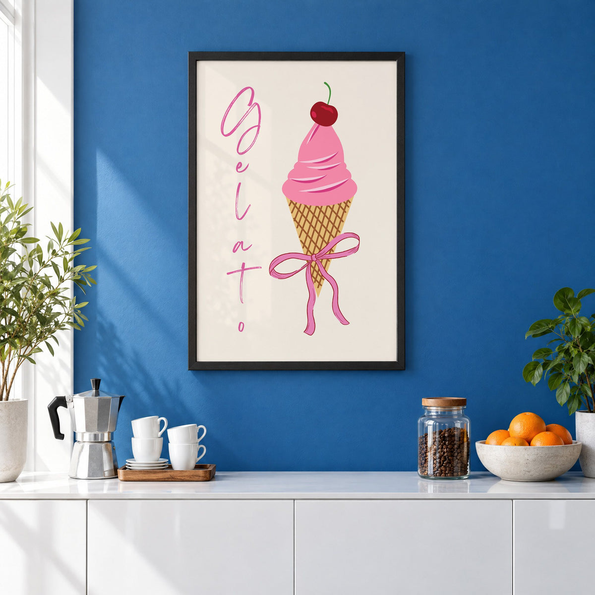 Gelato pink cone with bow print in a black frame on a cobalt blue wall above a coffee station