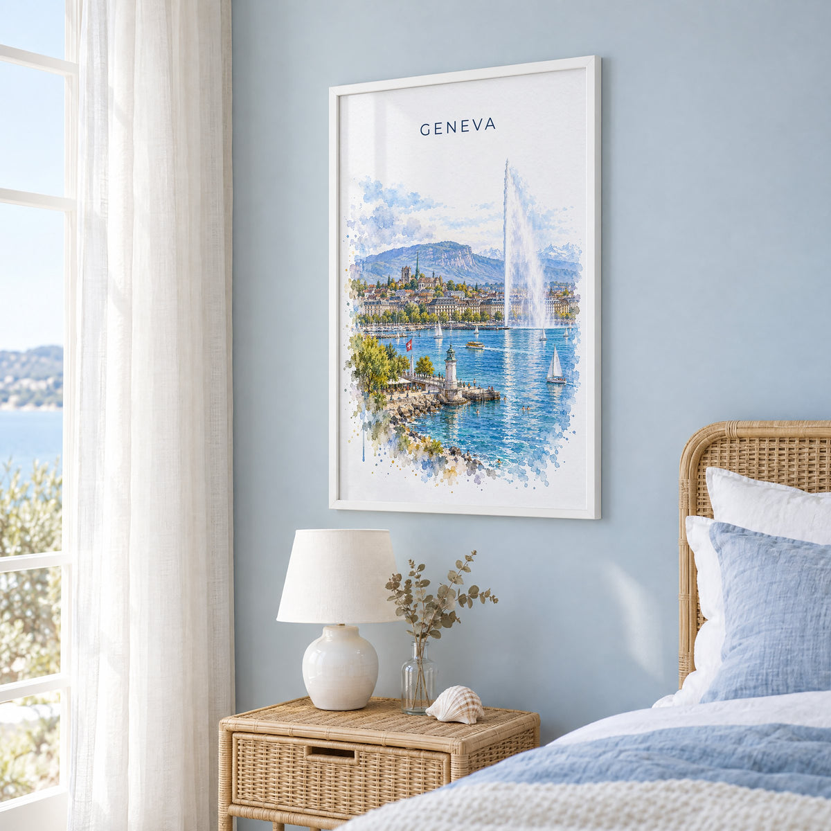 Geneva watercolor print in a white frame on a pale blue wall beside a rattan bed in a coastal bedroom