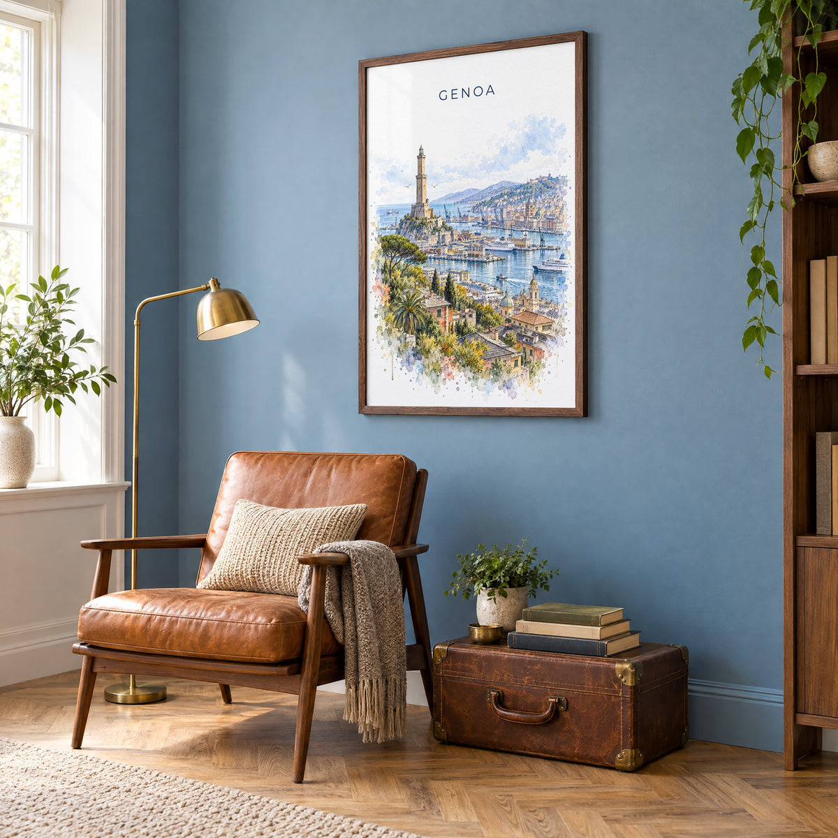 Genoa watercolor print in a walnut frame on a blue wall above a leather armchair in a reading nook