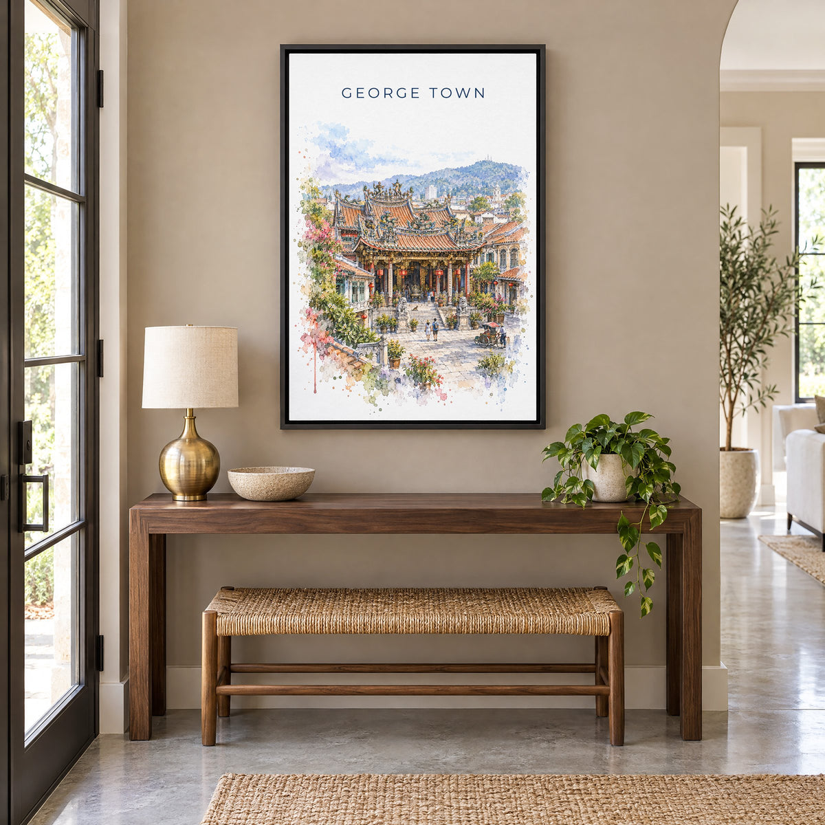 George Town, Malaysia watercolor print as a black floater canvas above a walnut console and woven bench in an entryway