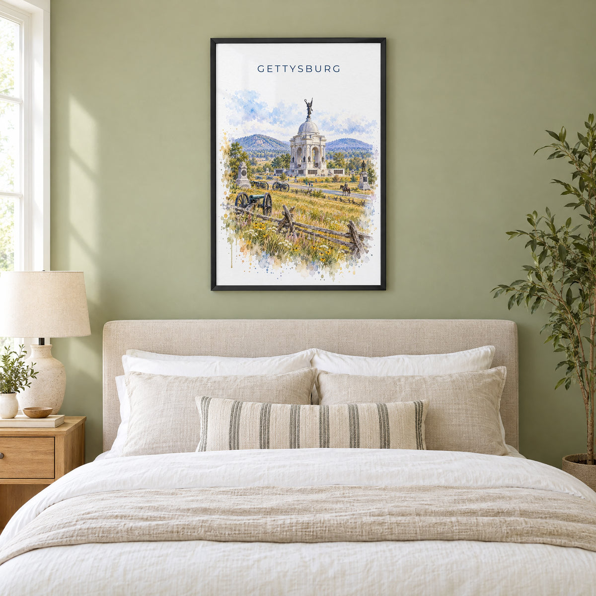 Gettysburg watercolor print in a black frame above an upholstered headboard in a sage green bedroom