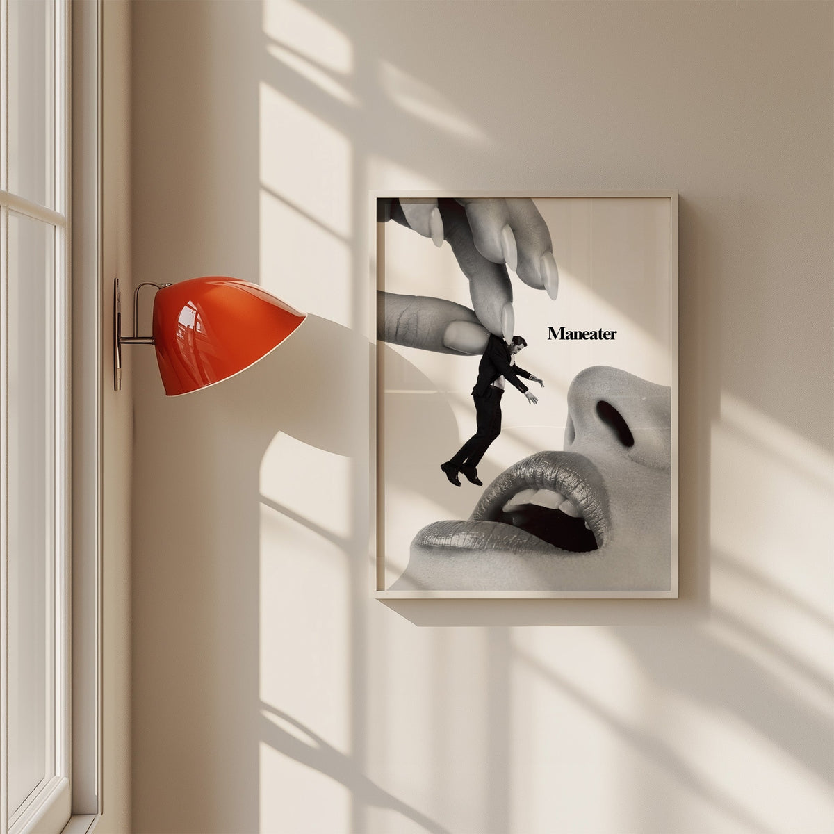Giant hand lifting tiny suited man collage print in a white frame on a sunlit wall beside a red sconce