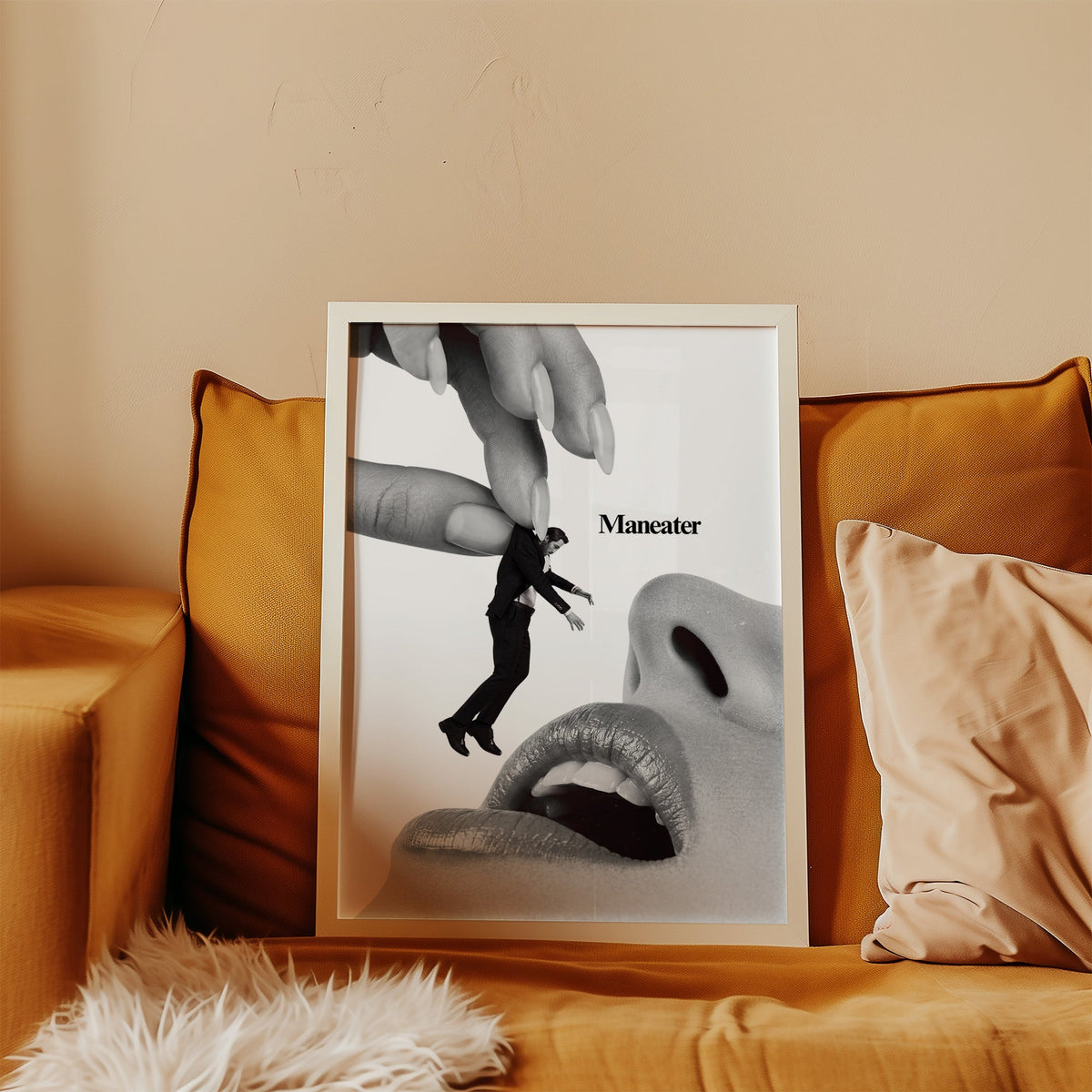 Giant hand lifting tiny suited man collage print in a white frame leaning on a mustard velvet sofa