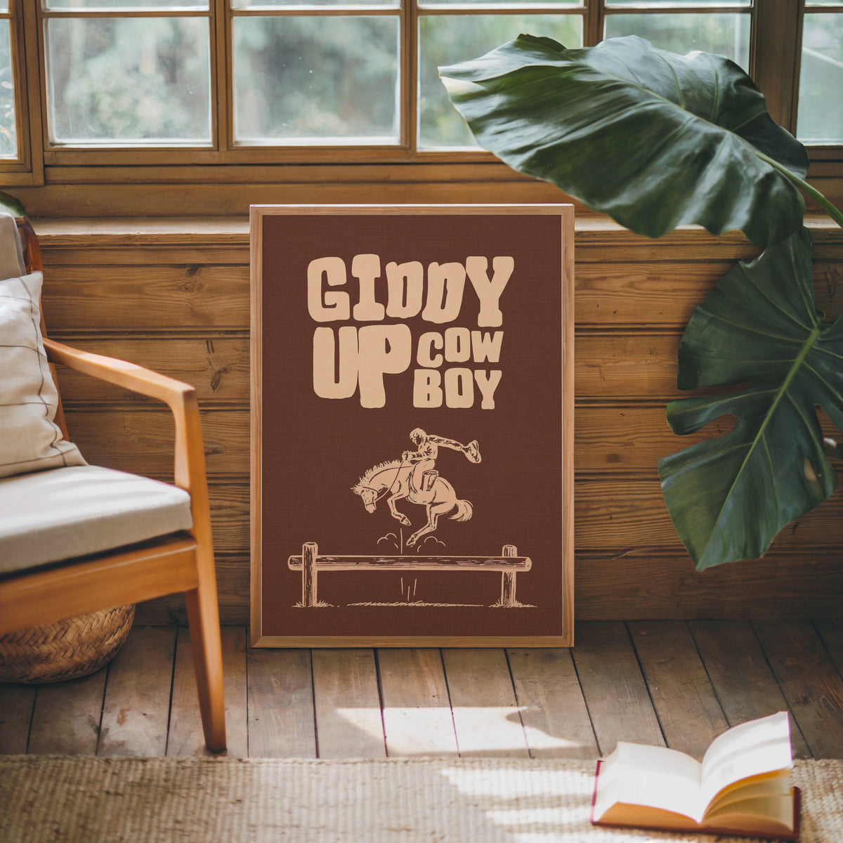 Giddy Up Cowboy brown print in an oak frame against a wood panel cabin wall