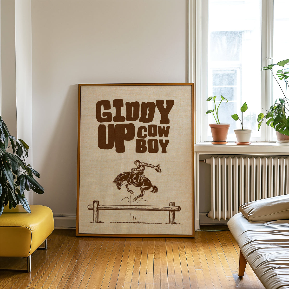 Giddy Up Cowboy cream print in an oak frame on a parquet floor beside a yellow bench