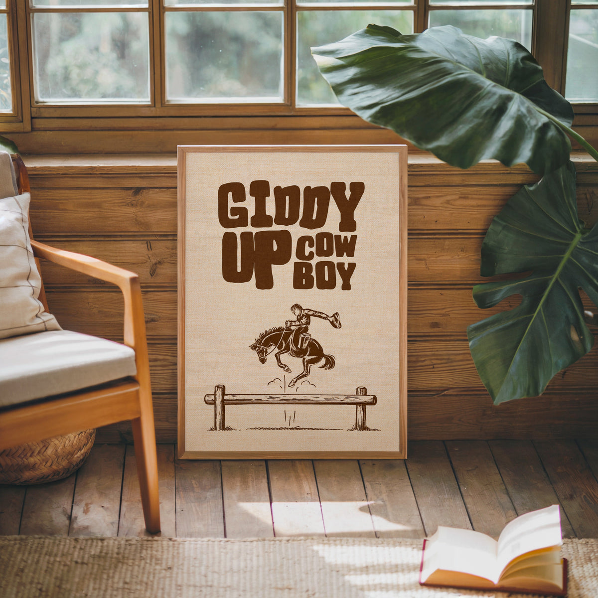Giddy Up Cowboy cream print in an oak frame against a wood panel cabin wall