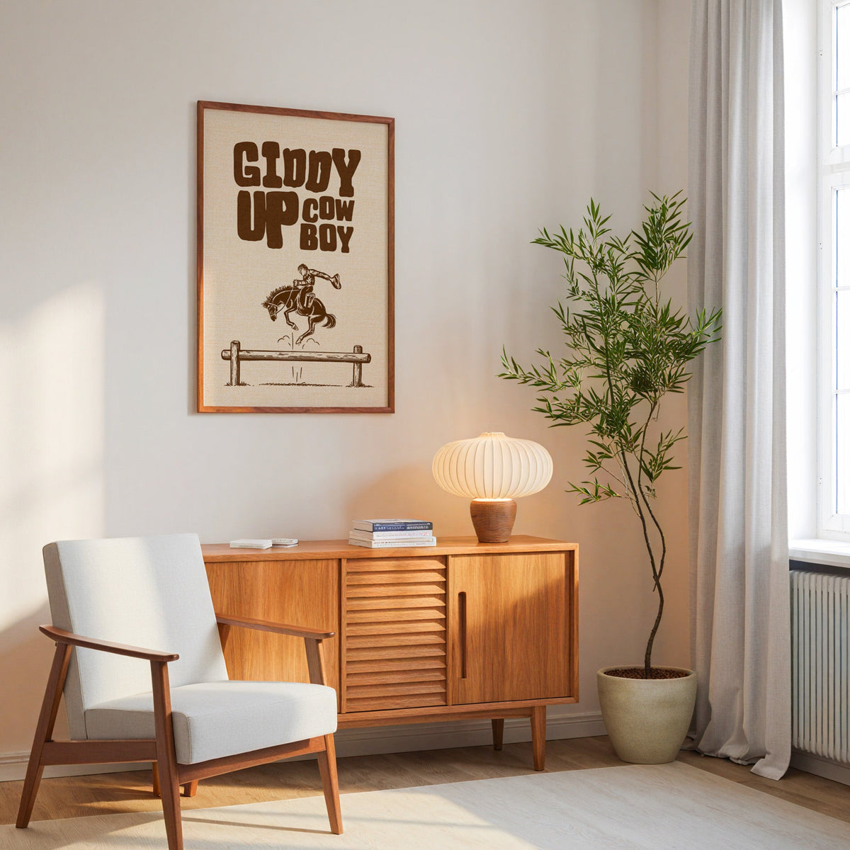 Giddy Up Cowboy cream print in an oak frame above a mid-century sideboard
