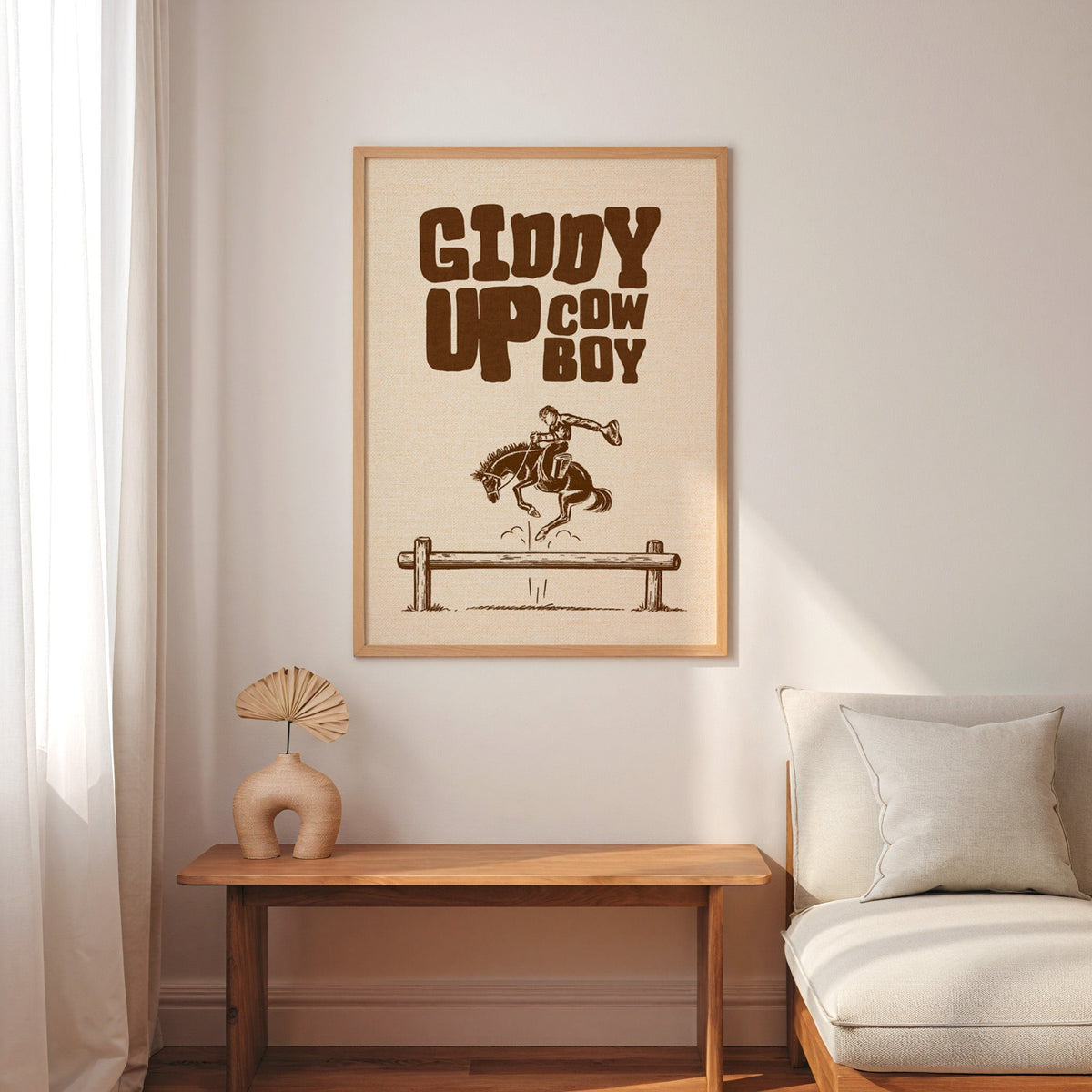 Giddy Up Cowboy cream print in an oak frame above a console with an arch vase