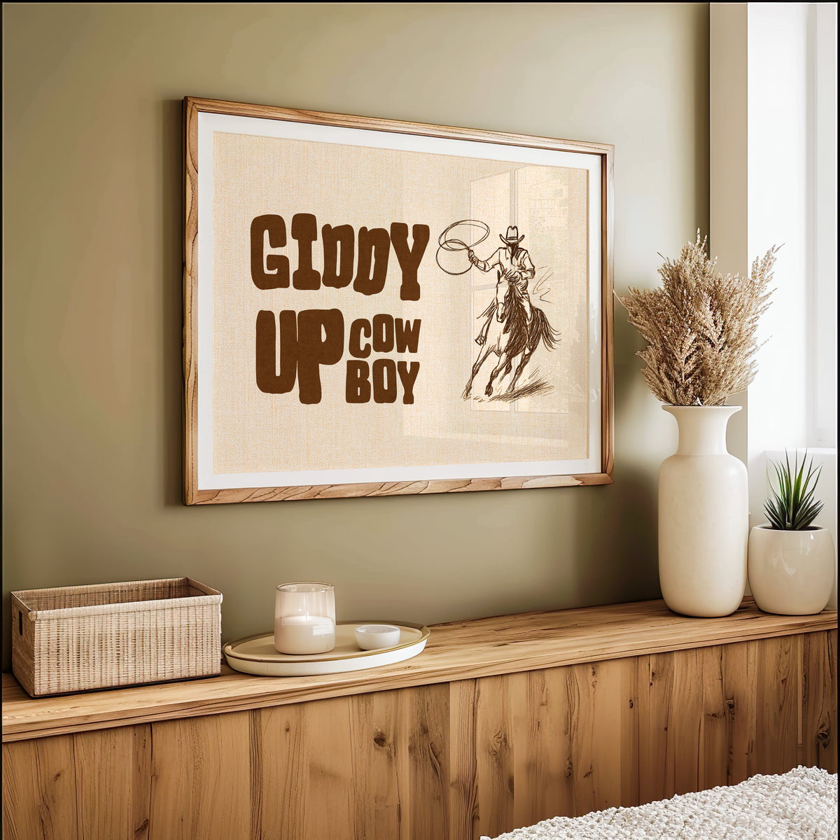 Giddy up cowboy lasso print in an oak frame on an olive wall with pampas grass