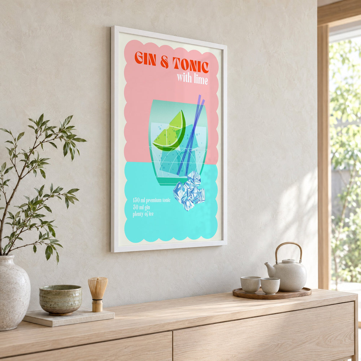 Gin & Tonic with lime aqua print in a white frame above a pale wood console with a matcha tea set