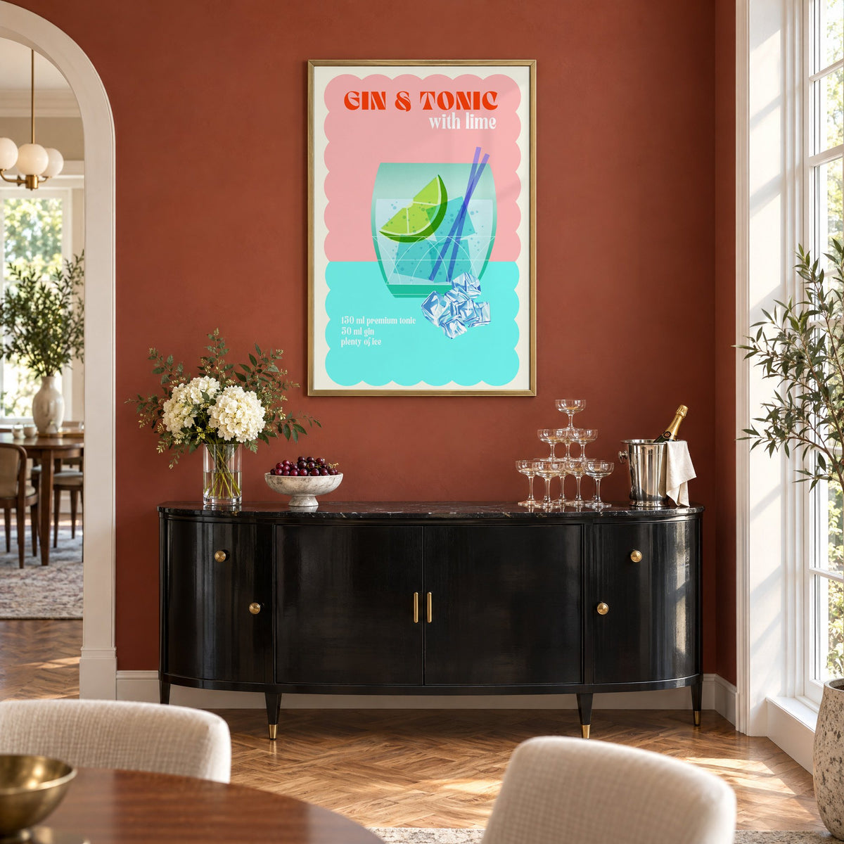 Gin & Tonic with lime aqua print in a brass frame on a terracotta wall above a black buffet with a champagne tower