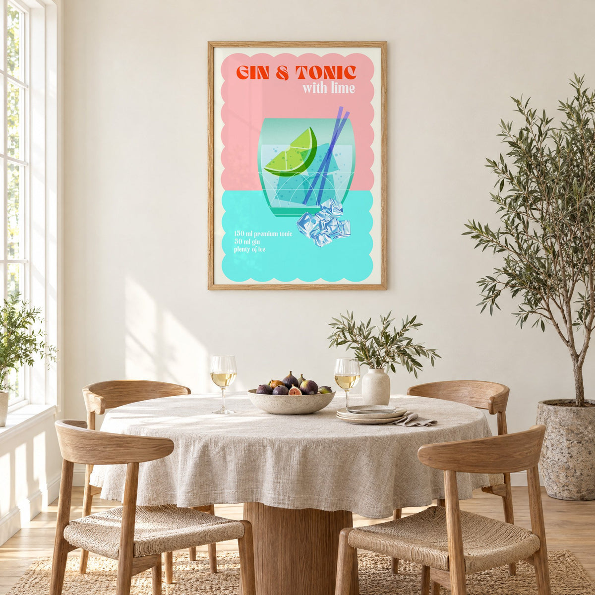 Gin & Tonic with lime aqua print in an oak frame above a round linen-covered dining table with figs and wine