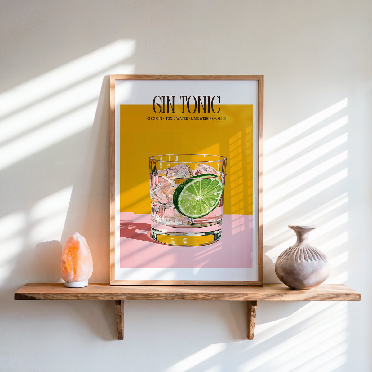 Gin and tonic recipe print in an oak frame on a live-edge shelf beside a salt lamp