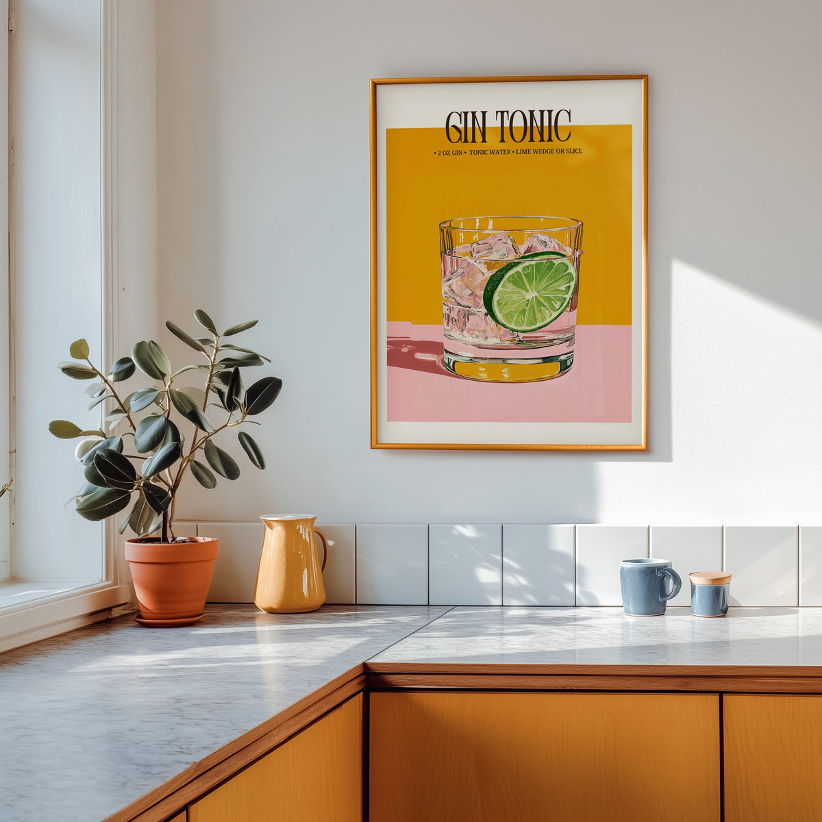 Gin and tonic recipe print shown in a gold frame above a marble counter in a tan kitchen