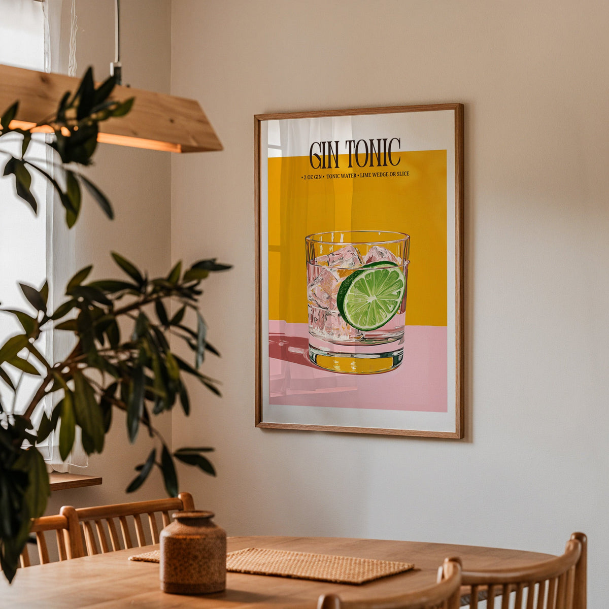 Gin and tonic recipe print in a walnut frame above a dining table with olive branches