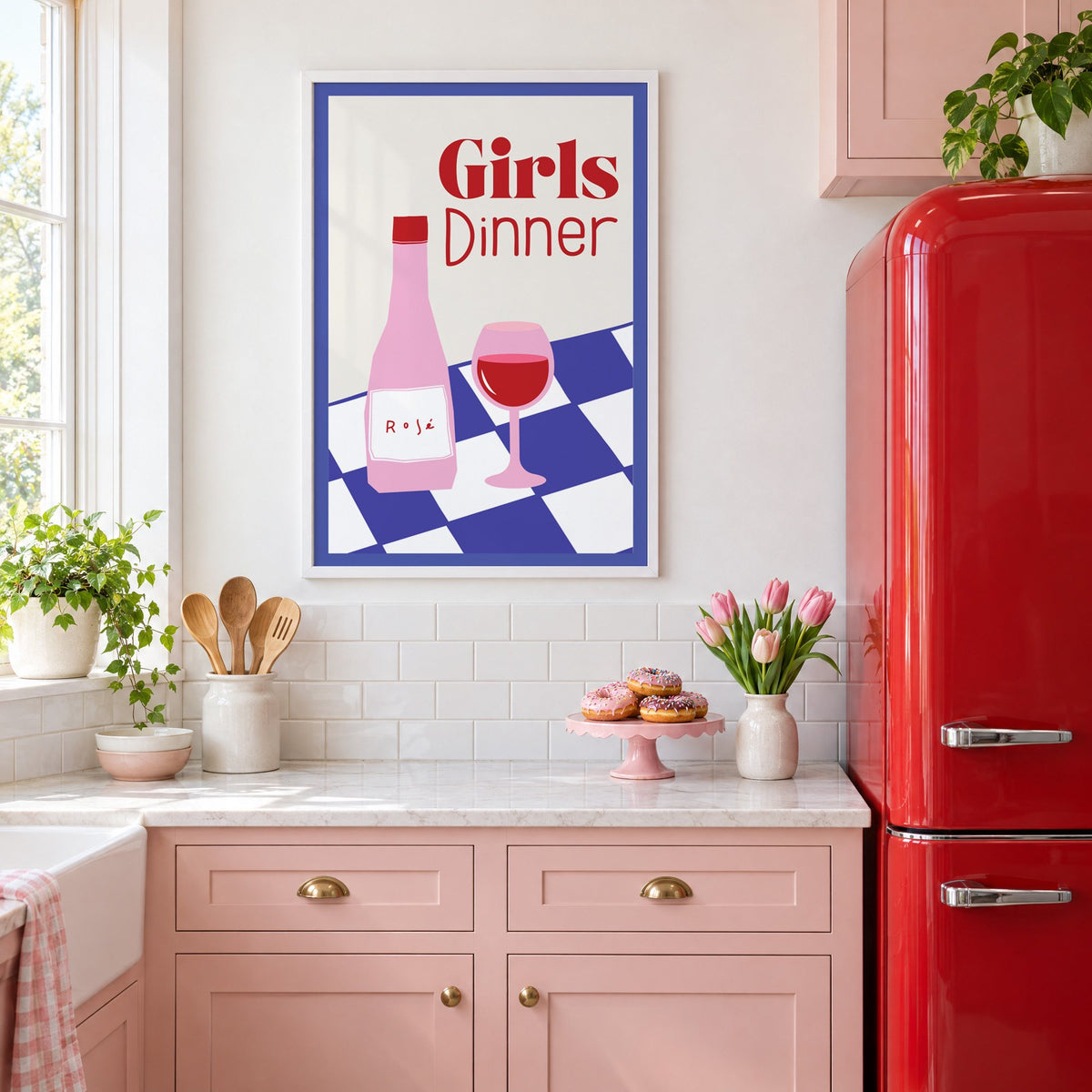 Girls Dinner rosé bottle on checkered table print in a white frame above pink cabinets beside a red retro fridge