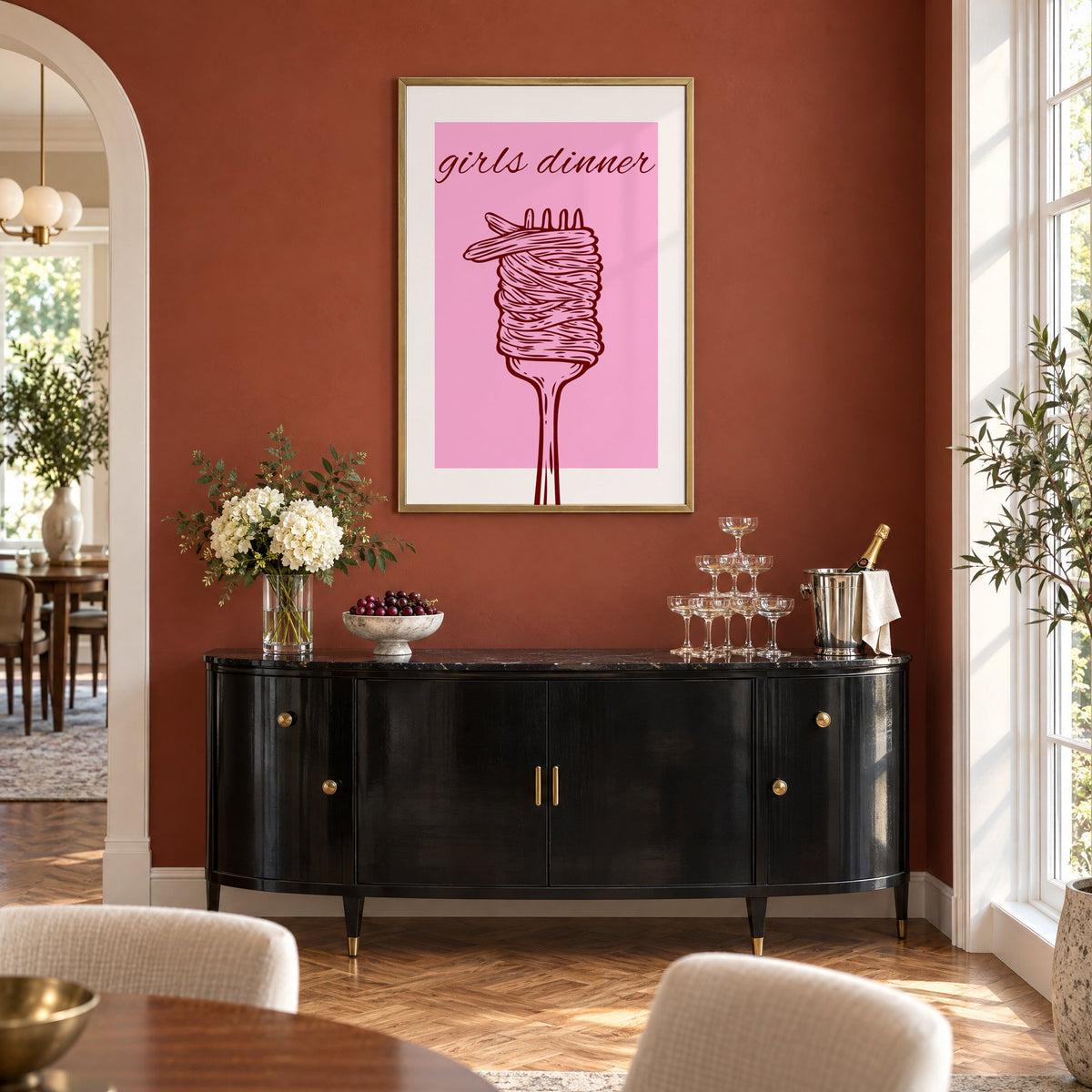 Girls dinner spaghetti fork pink print in a brass frame on a terracotta wall above a black buffet with a champagne tower