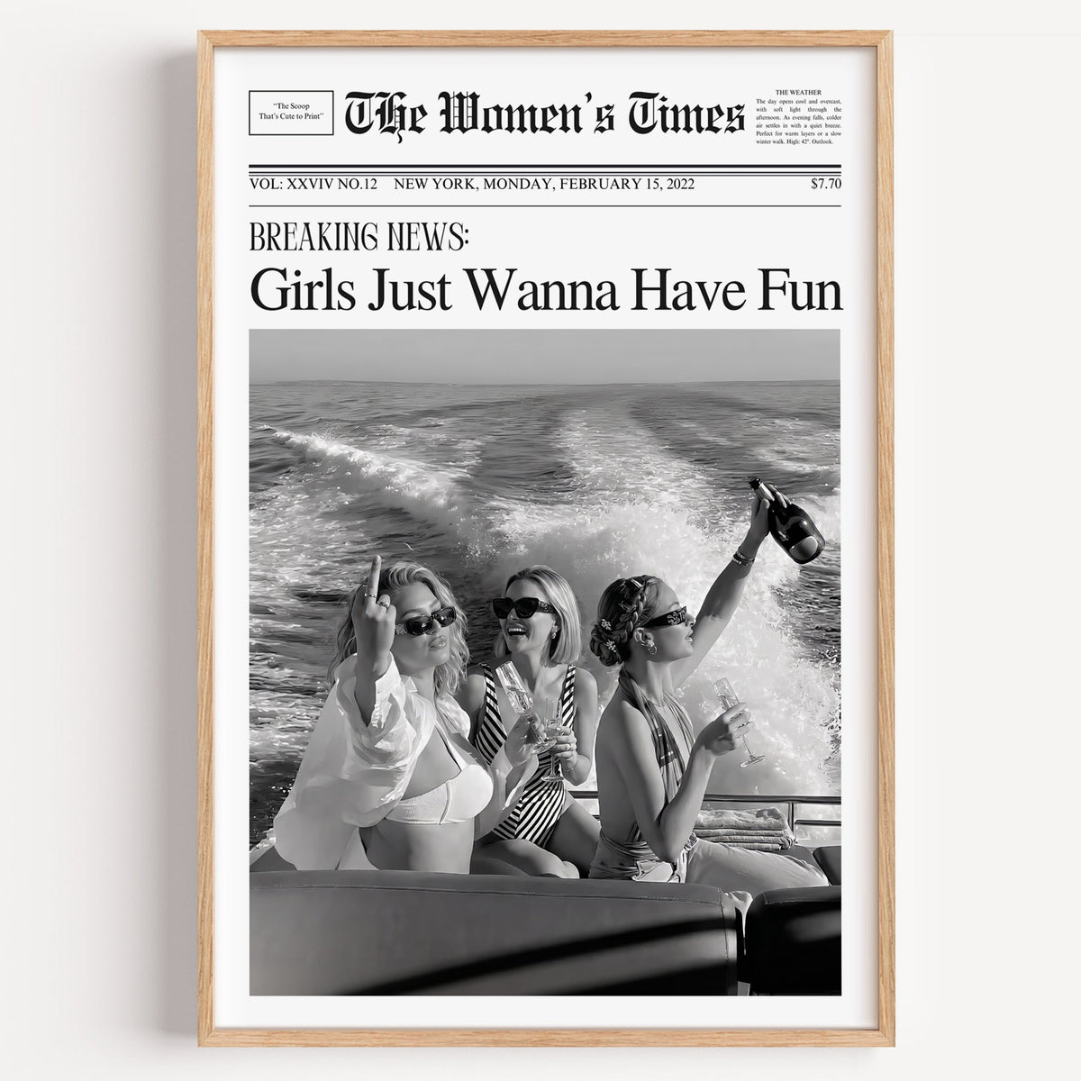 Mock front page with three women on a yacht print in a light oak frame on a plain white wall