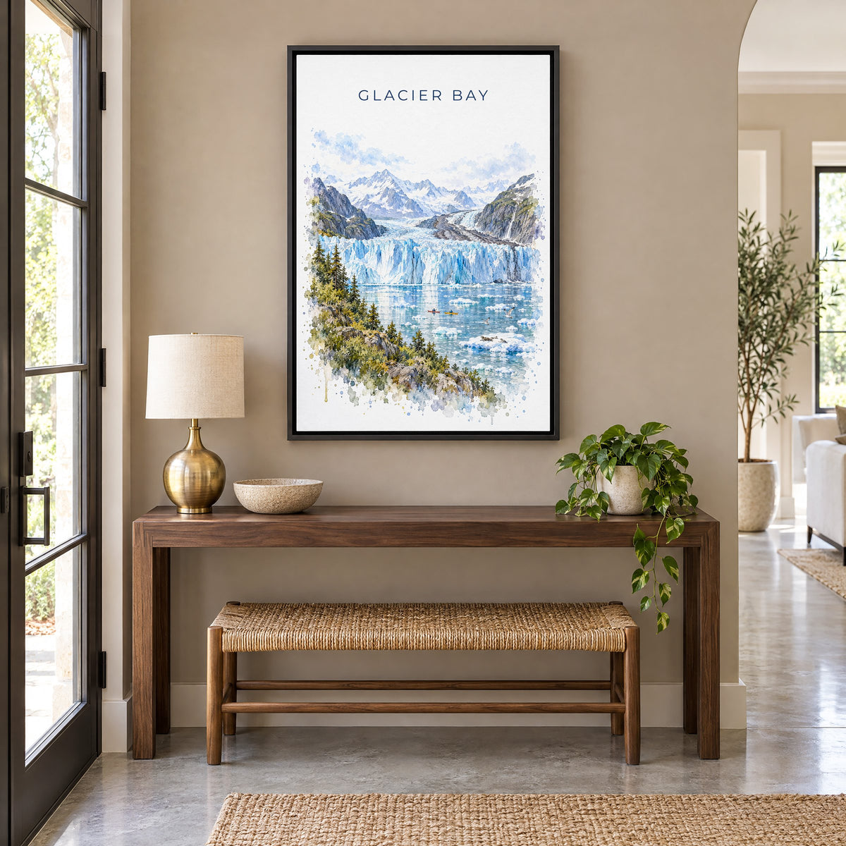 Glacier Bay National Park watercolor print as a black floater canvas above a walnut console and woven bench in an entryway