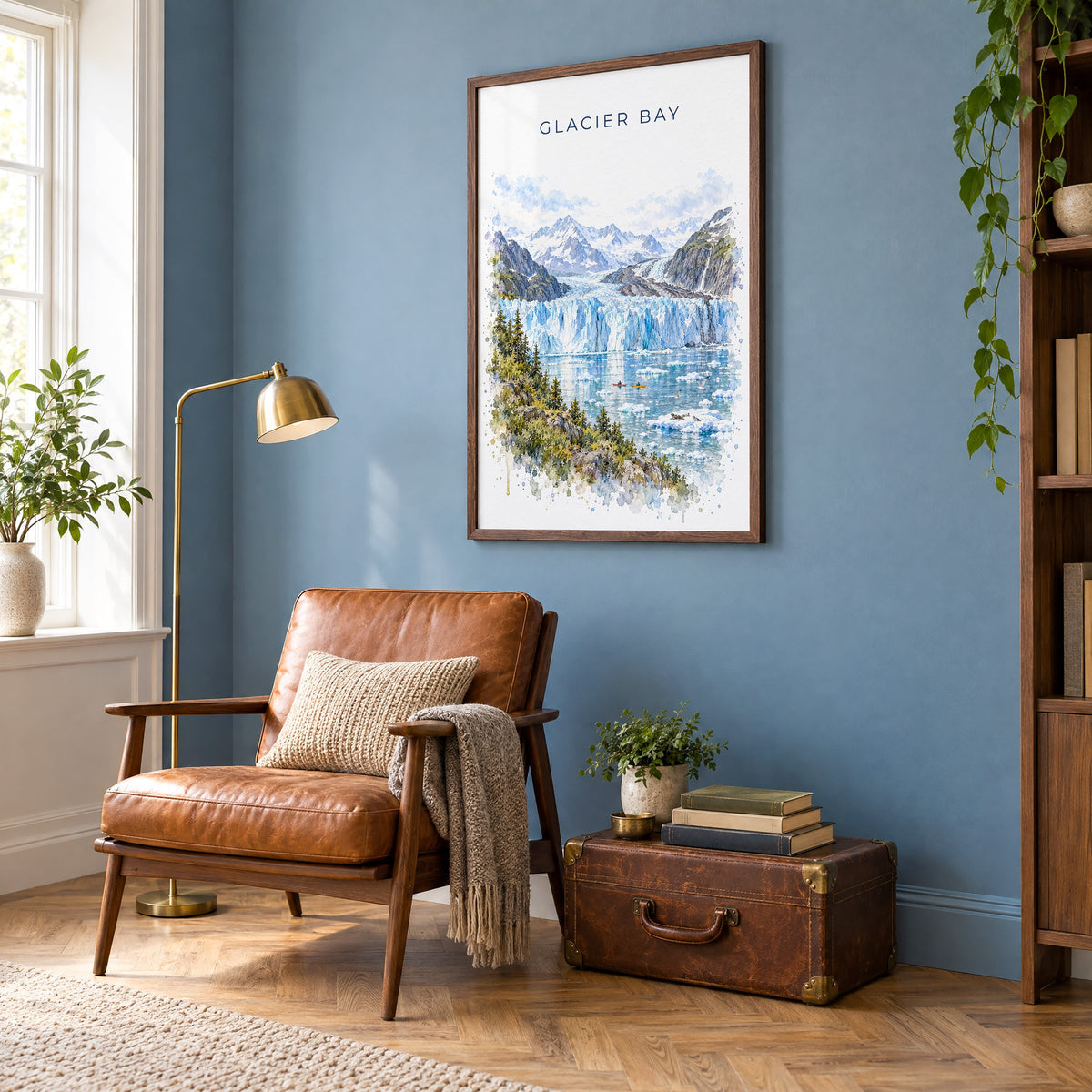 Glacier Bay National Park watercolor print in a walnut frame on a blue wall above a leather armchair in a reading nook