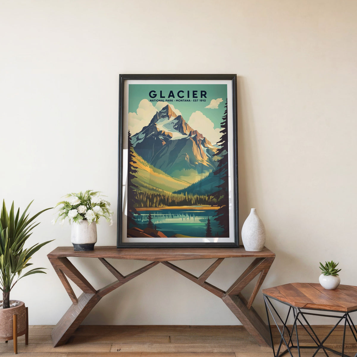 Glacier poster in a black frame on an entryway console table beside white flowers and a yucca