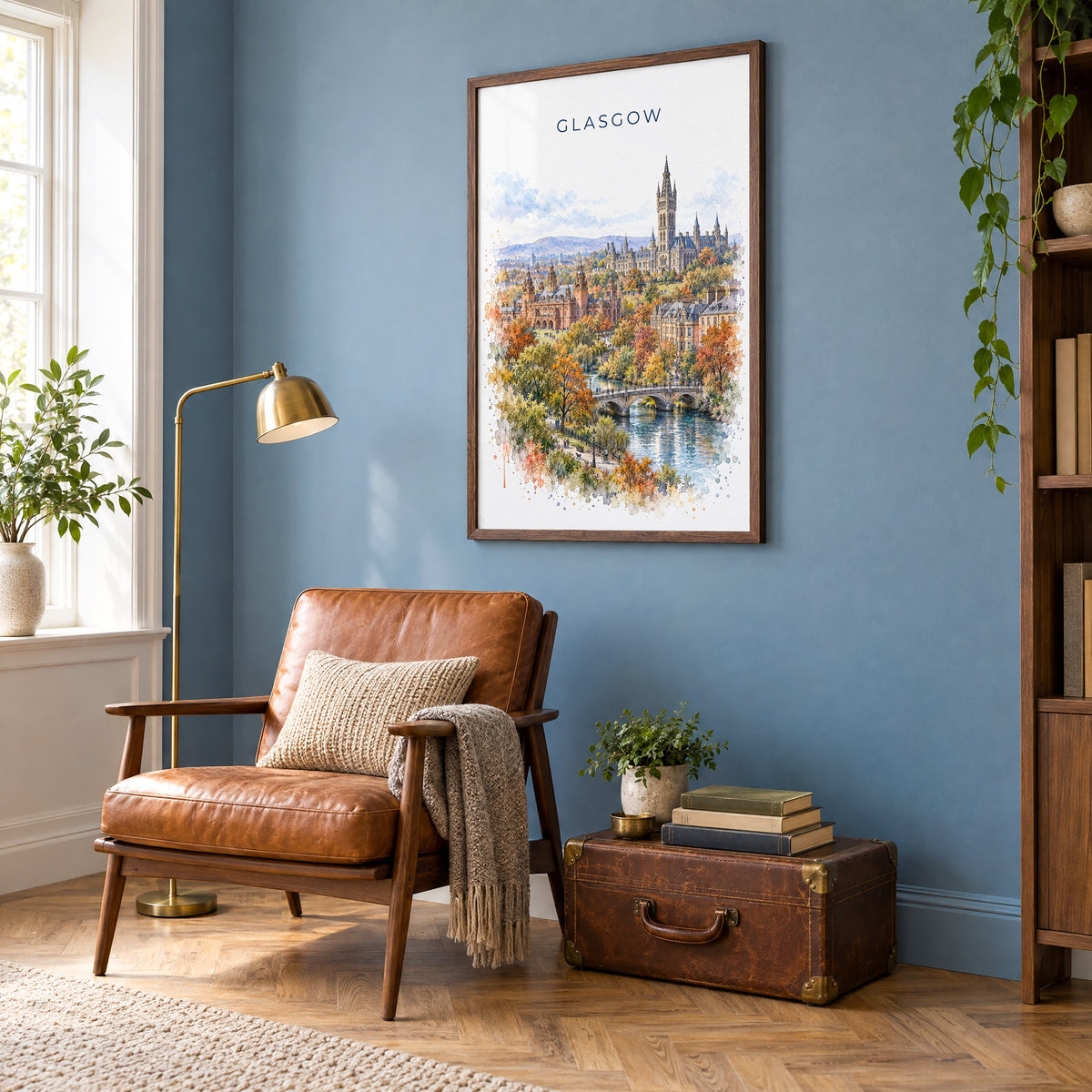 Glasgow watercolor print in a walnut frame on a blue wall above a leather armchair in a reading nook