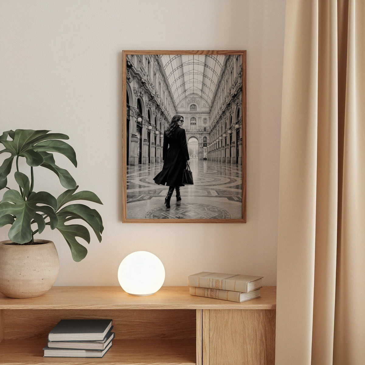 Black and white woman in a glass arcade print in a walnut frame above an oak cabinet with a glowing globe lamp