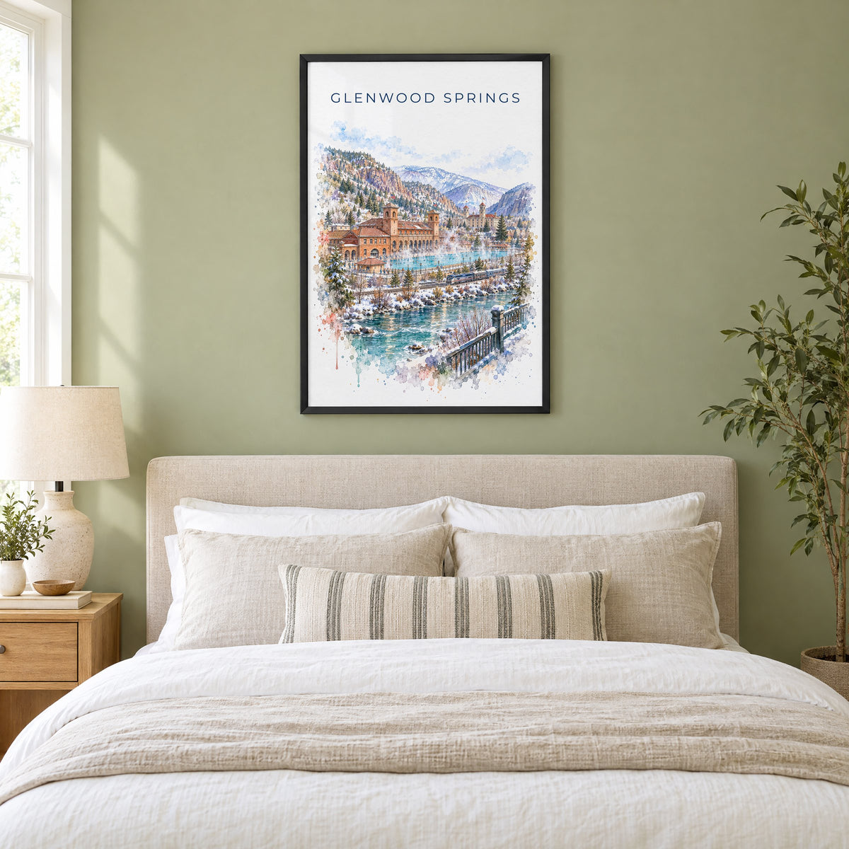 Glenwood Springs watercolor print in a black frame above an upholstered headboard in a sage green bedroom
