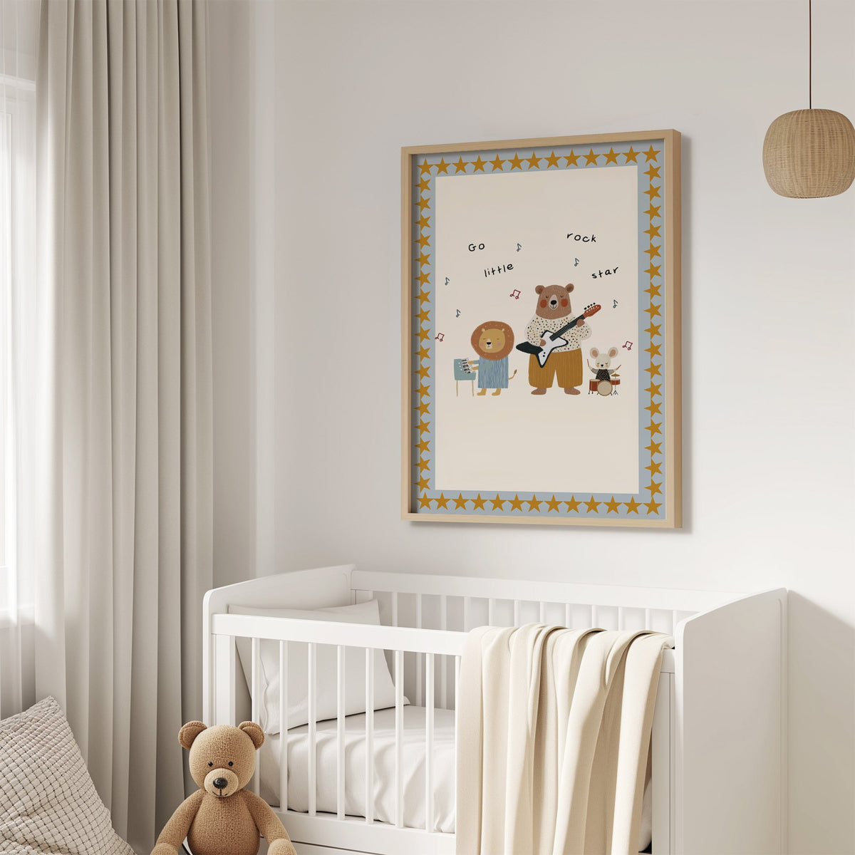 Go little rock star band nursery print in an oak frame above a white crib with a teddy bear