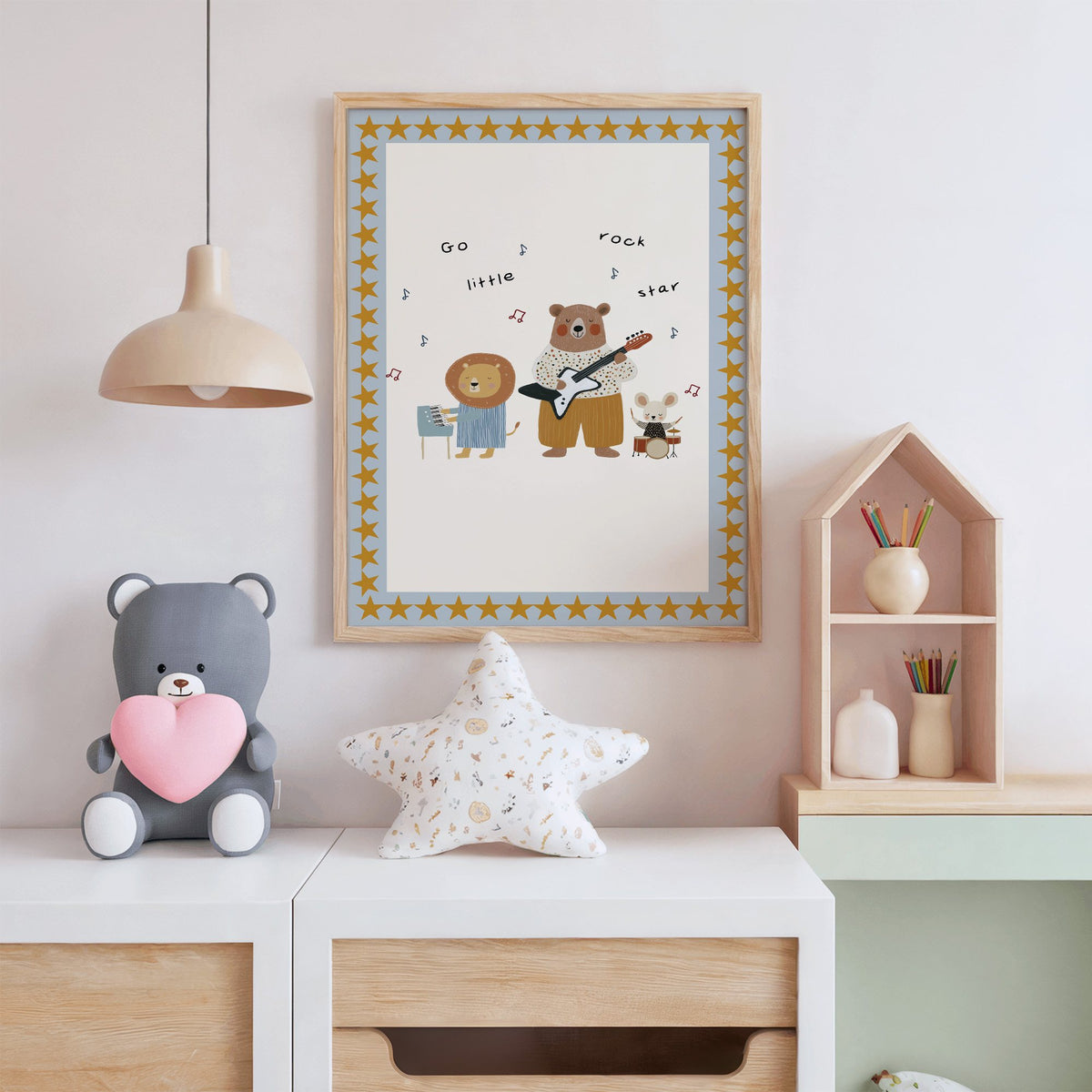 Go little rock star band nursery print in an oak frame above a white dresser with a star pillow and house shelf