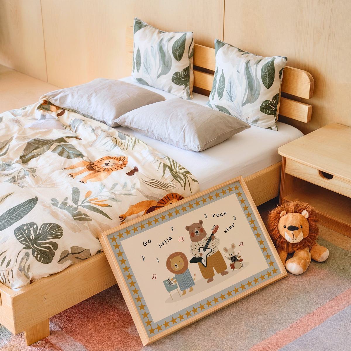 Landscape go little rock star band nursery print in an oak frame leaning on a kids bed by a lion plush