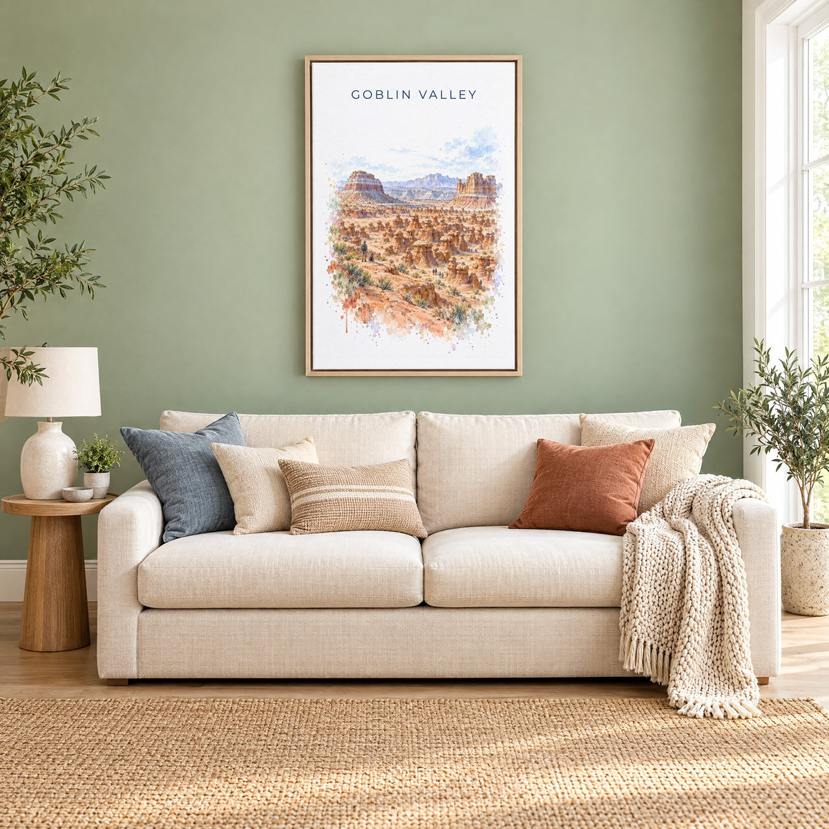 Goblin Valley State Park watercolor print as a natural floater canvas above a cream linen sofa on a sage green wall