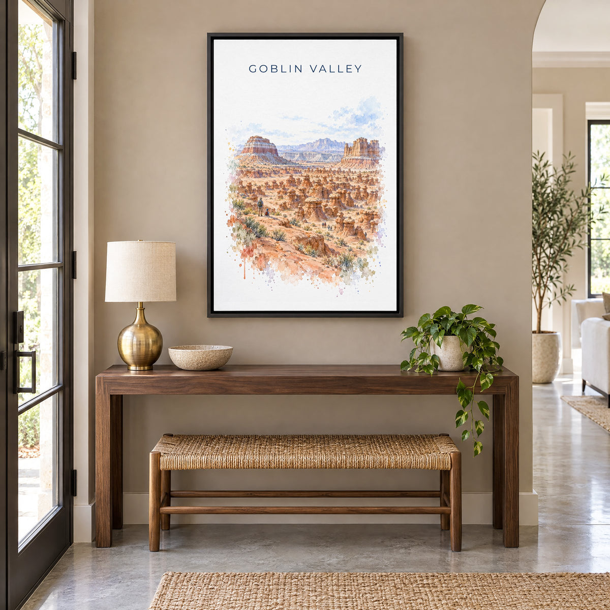 Goblin Valley State Park watercolor print as a black floater canvas above a walnut console and woven bench in an entryway