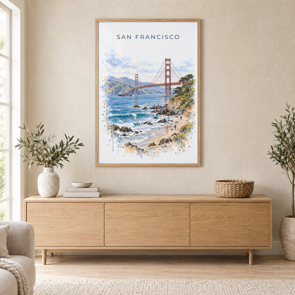 Golden Gate Bridge watercolor print in an oak frame above a light wood sideboard in a Scandinavian living room
