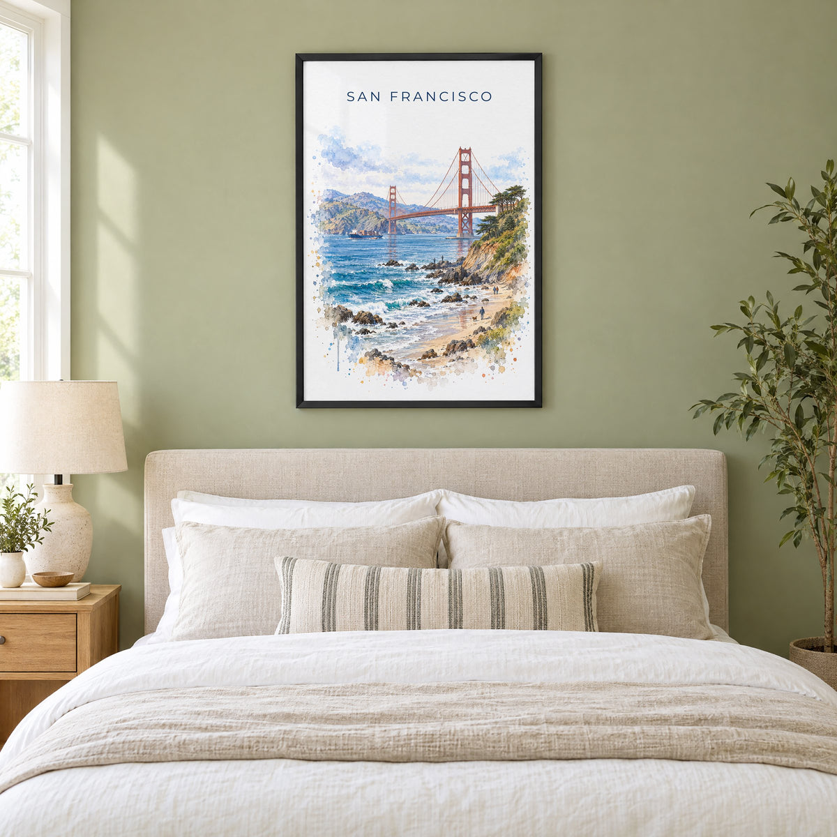 Golden Gate Bridge watercolor print in a black frame above an upholstered headboard in a sage green bedroom