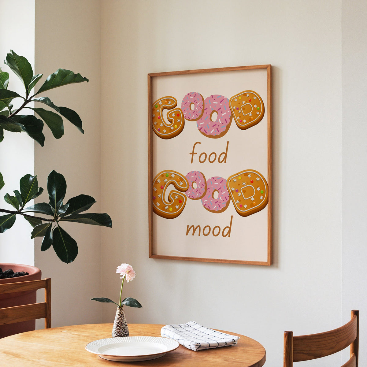 Good Food Good Mood donut print in a walnut frame above a round table beside a fiddle-leaf fig