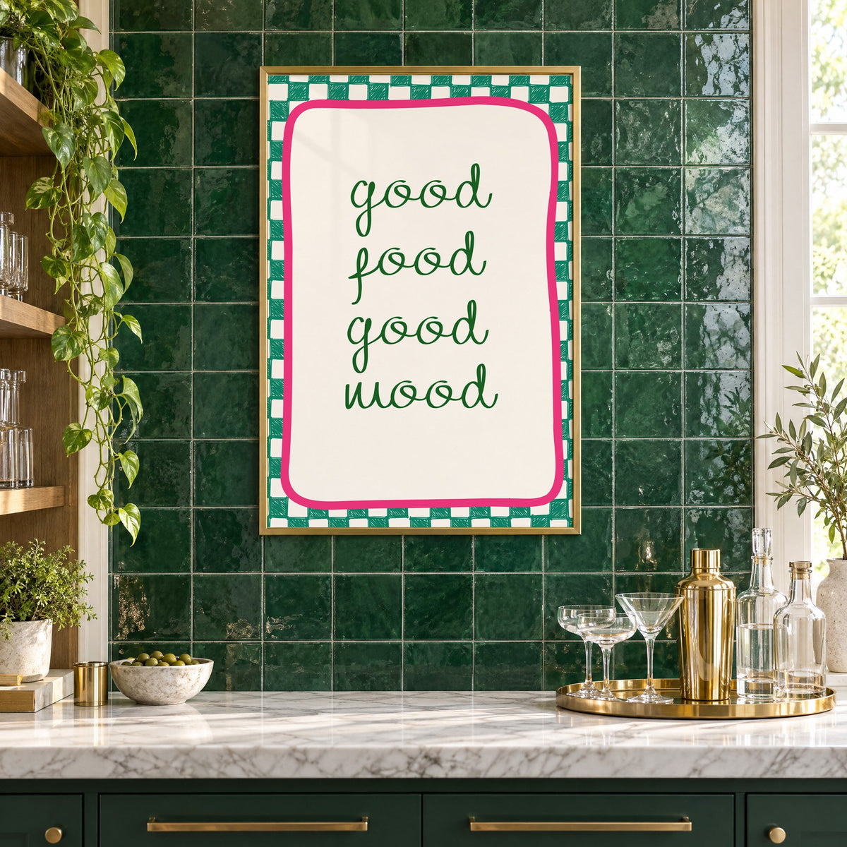 Good food good mood checkered print in a brass frame on emerald green tiles above a home bar with coupe glasses